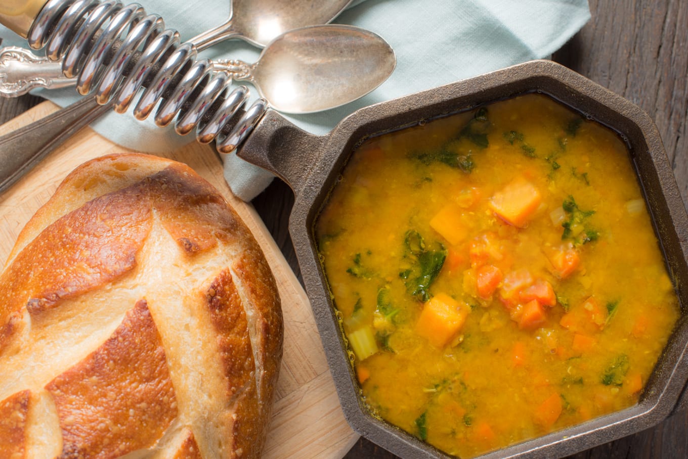 spiced lentil soup in small pot next to loaf of bread