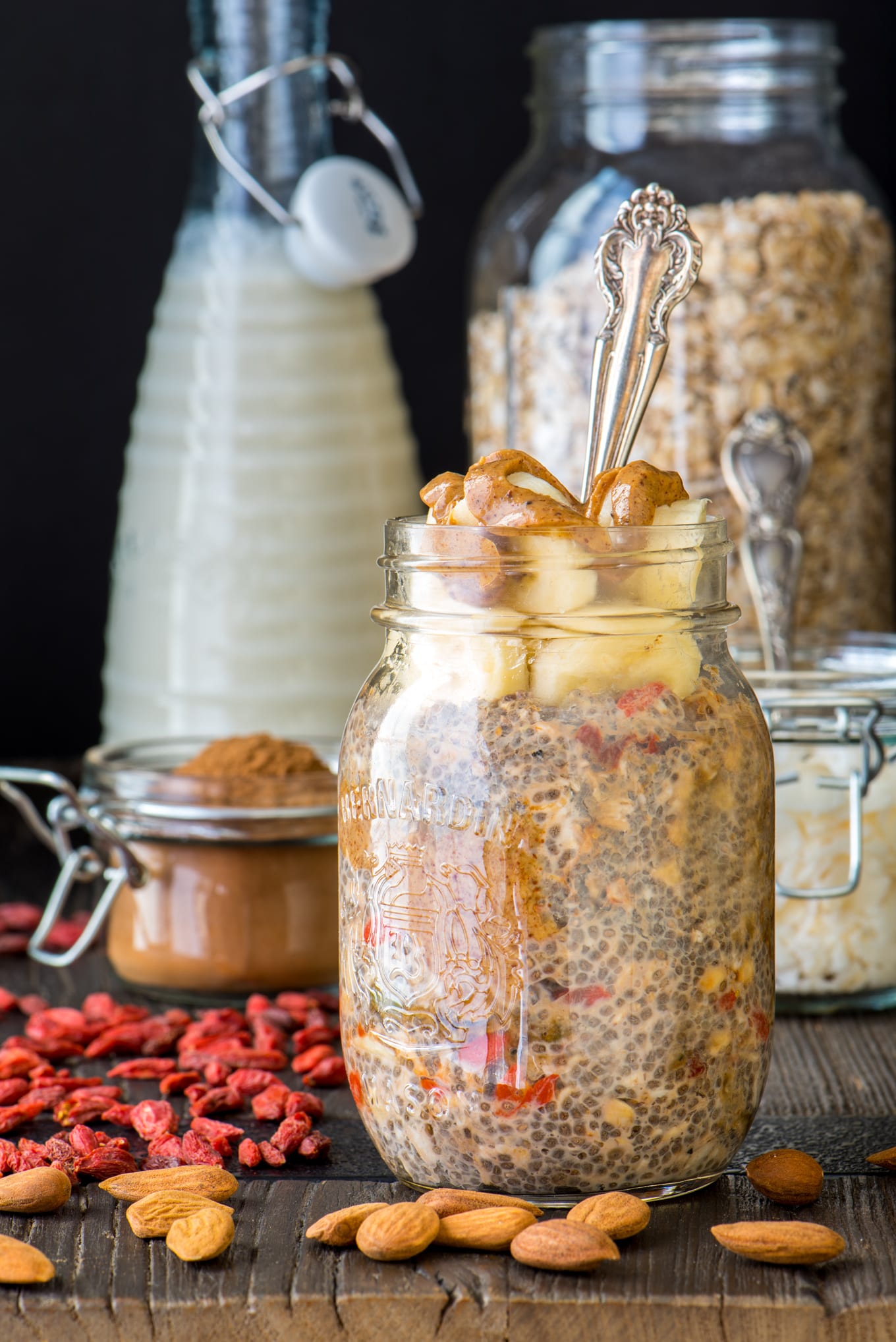 nut butter overnight oats in jar with almond milk and oats in jars in background