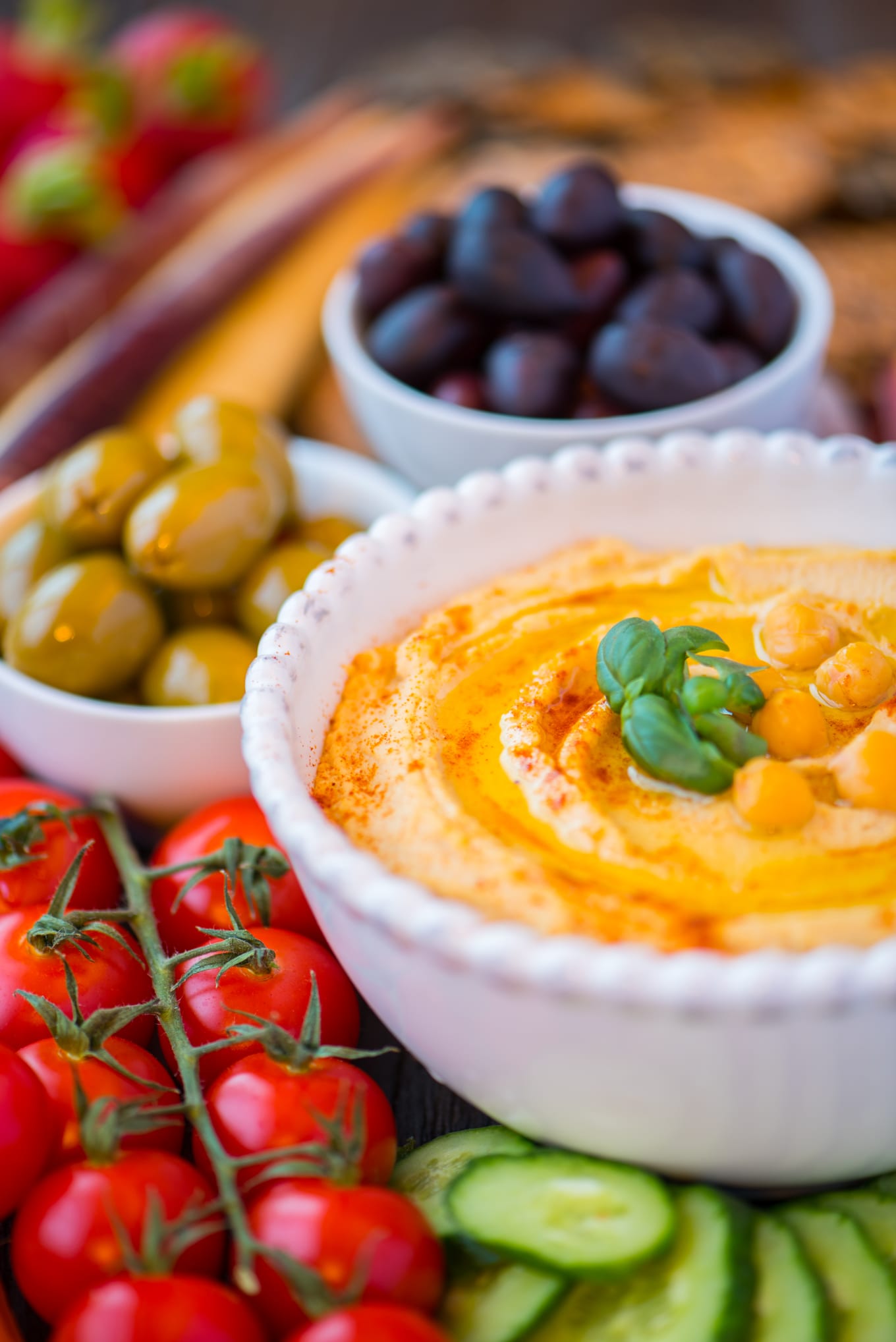 hummus in bowl surrounded by vegetables