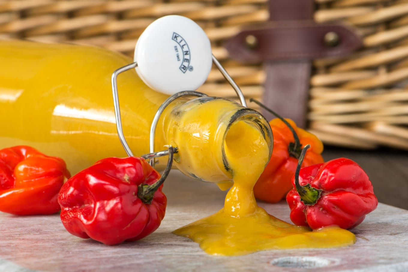 tangy mango lime hot sauce in bottle laying on side with sauce pouring out