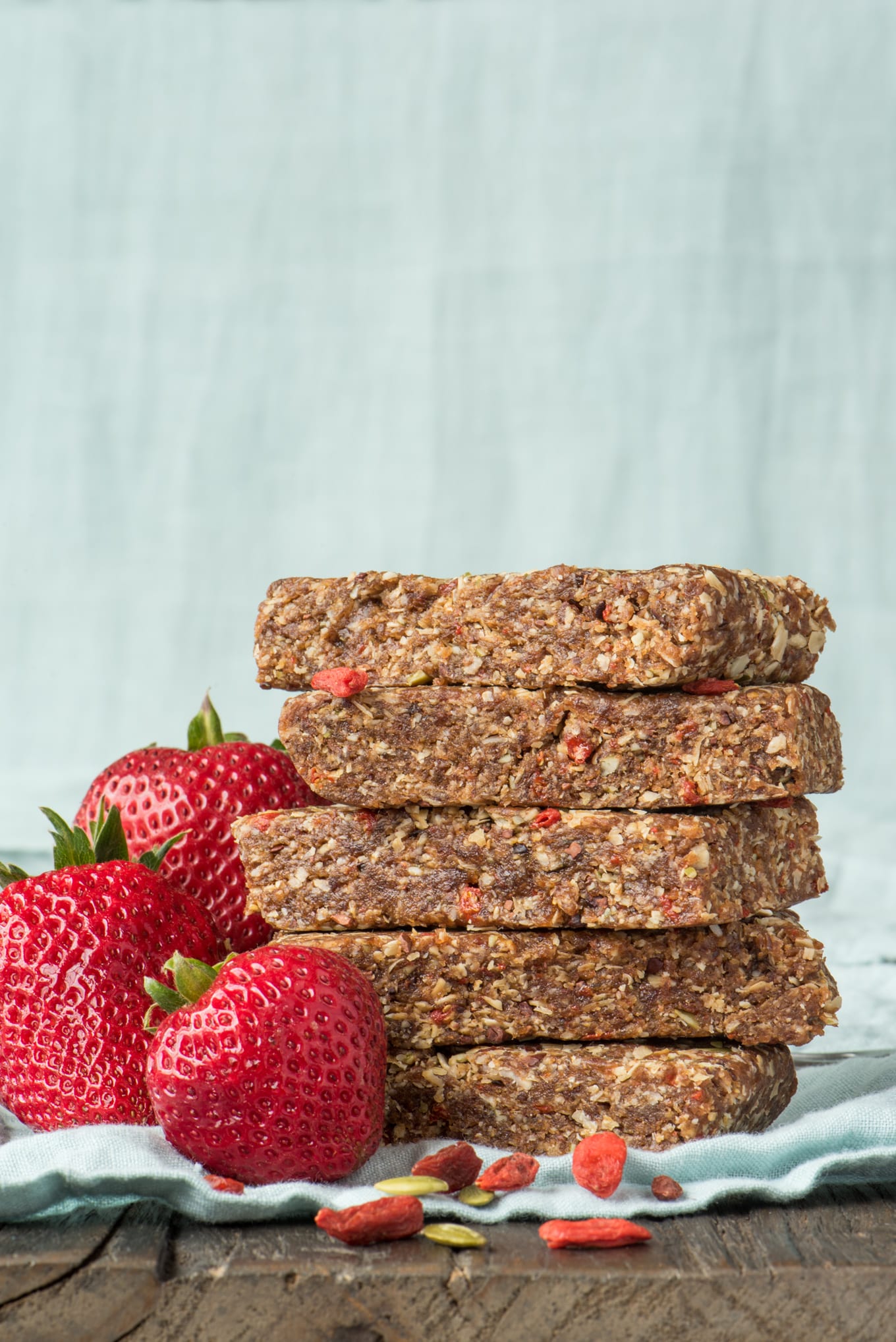 no-bake granola bars stacked next to strawberries