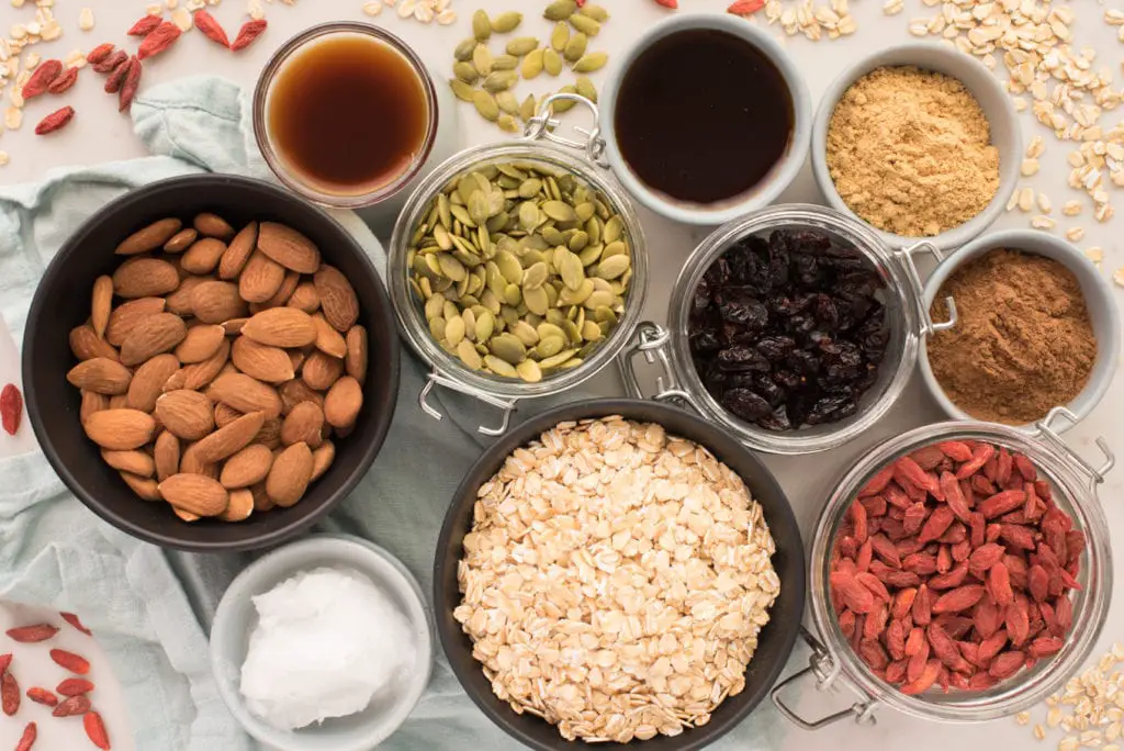 crunchy maple almond granola ingredients in bowls and jars