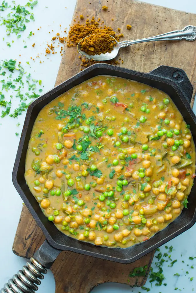 coconut chickpea curry masala in cast iron pan on bread board