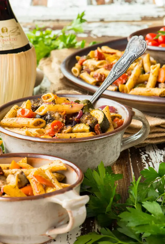 ratatouille pasta salad in bowls next to wine bottle