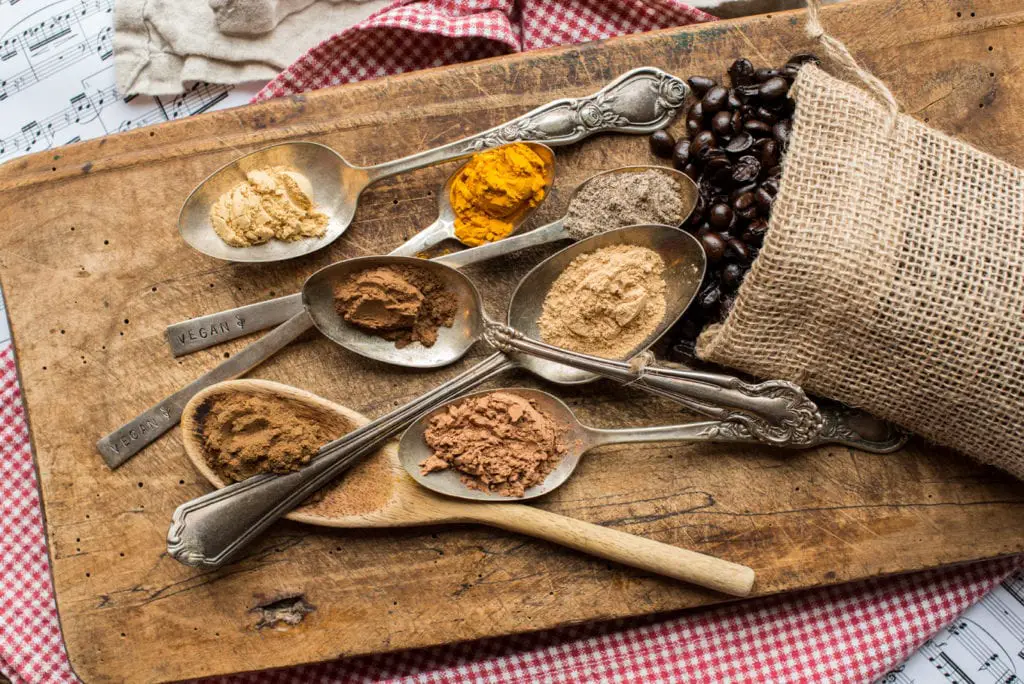 superfood coffee ingredients in spoons on cutting board