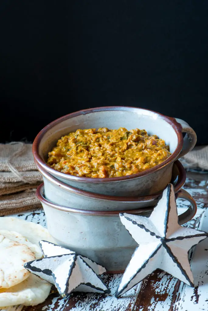 coconut lentil curry in bowl next to naan bread