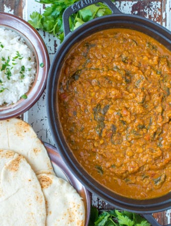 coconut lentil curry in pot next to nano bread and rice