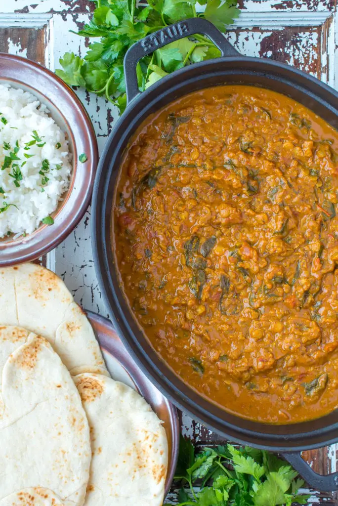 coconut lentil curry in pot next to nano bread and rice