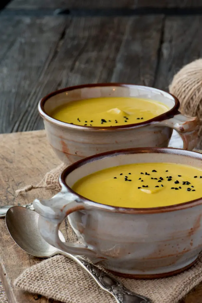 anti-inflammatory cauliflower soup in bowls on cutting board