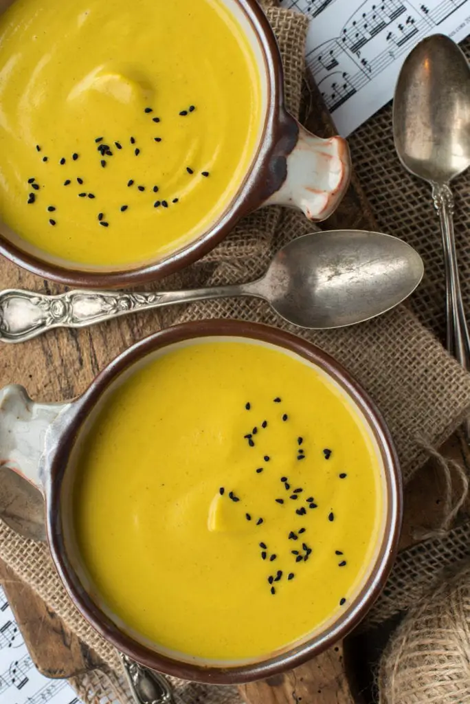 anti-inflammatory cauliflower soup in bowls on cutting board