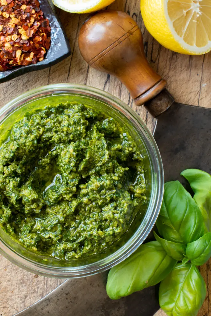 nut free basil pesto in jar on cutting board