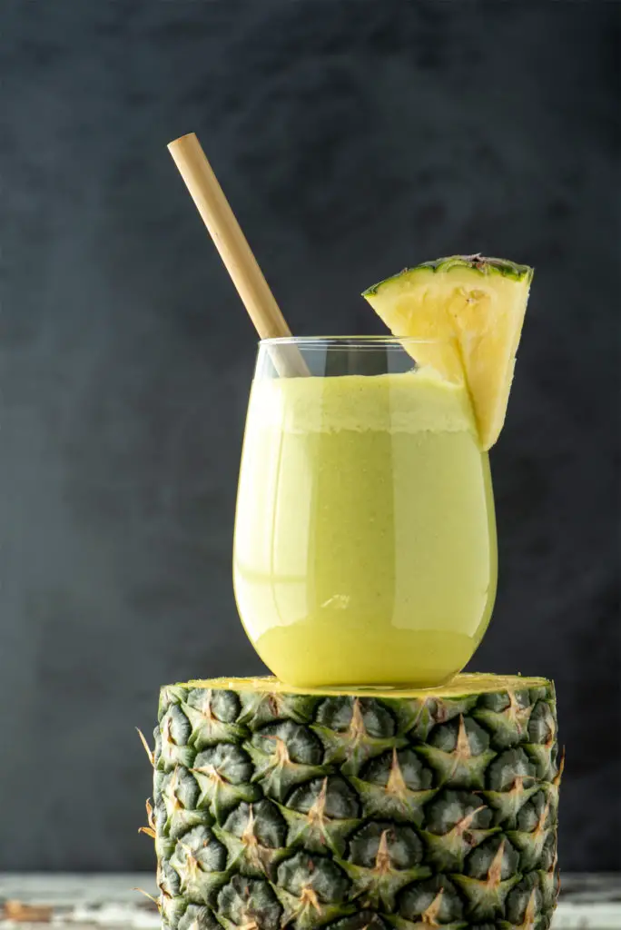 refreshing pineapple salsa smoothie in glass on slice of pineapple