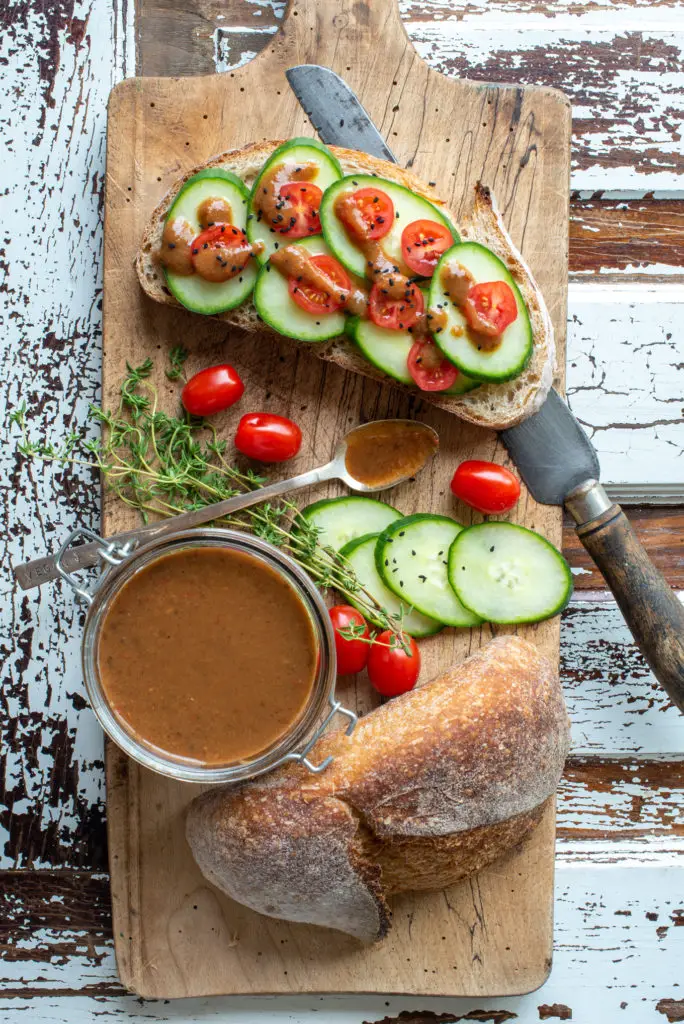 jerk style peach hot sauce in jar and on toast with cucumber and tomato