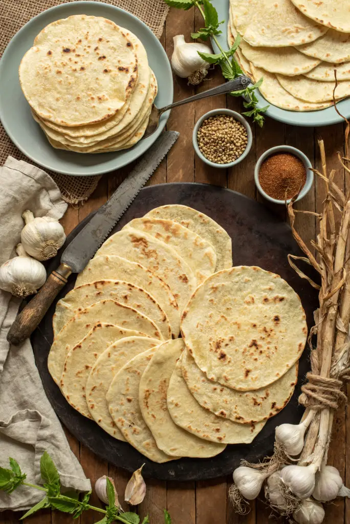 homemade flour tortillas on plates and pizza stone