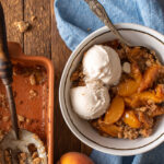 ginger peach crumble in bowl with ice cream