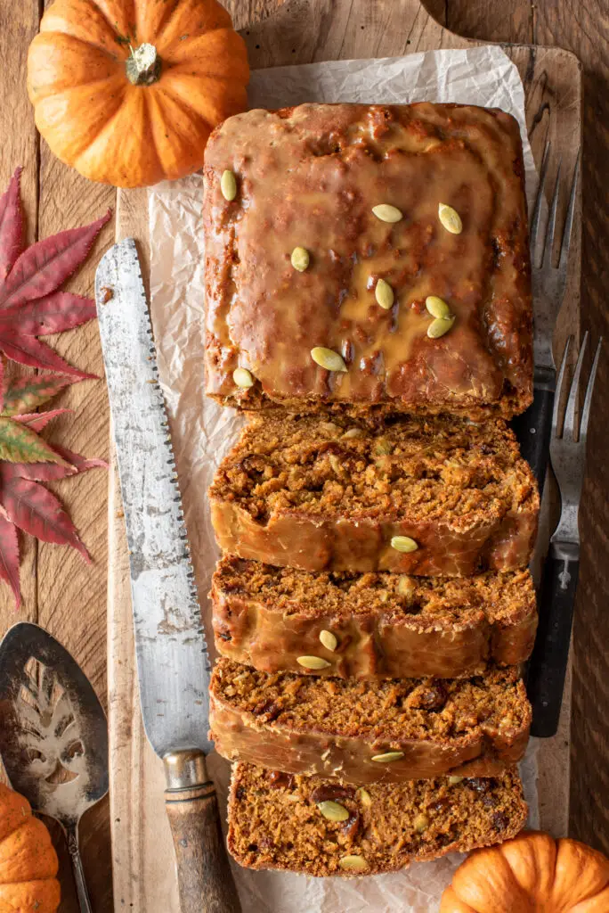 sliced maple cinnamon glazed pumpkin loaf on cutting board