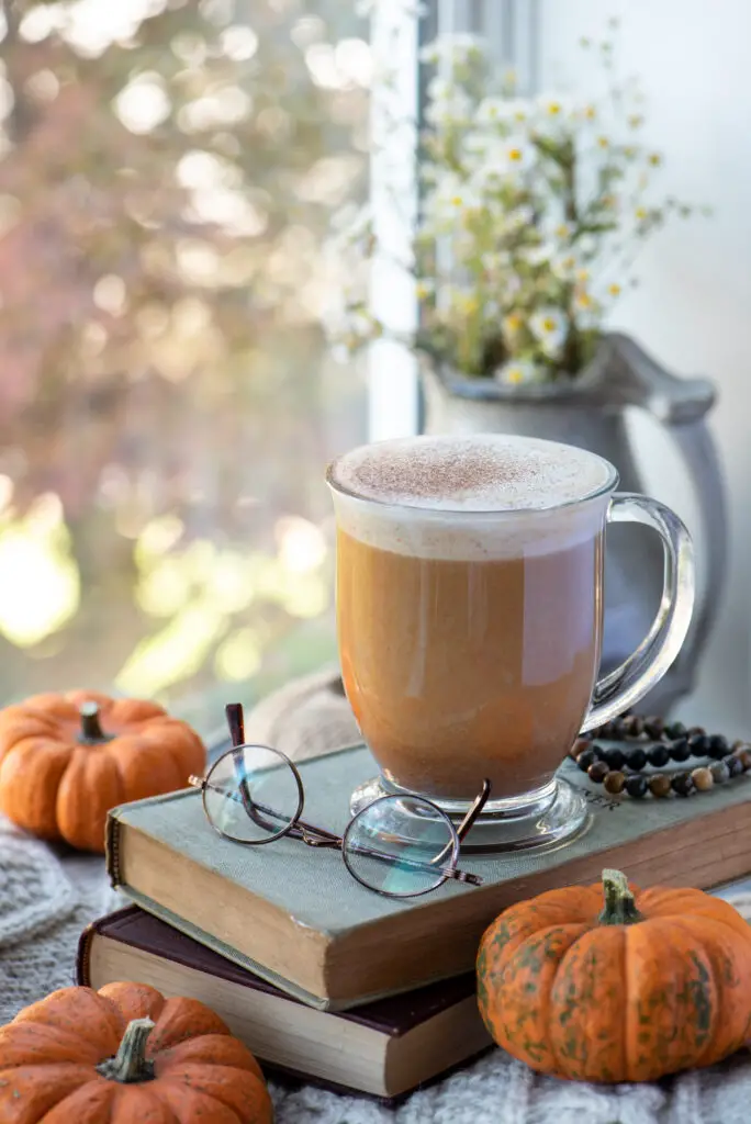 maple pumpkin spice latte in mug sitting on books