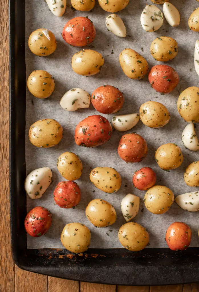 potatoes and garlic prepped on baking sheet