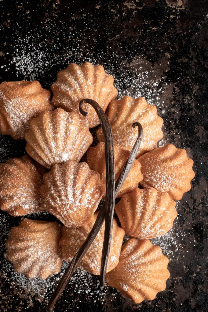 vegan french petites madeleines on baking sheet with vanilla pods