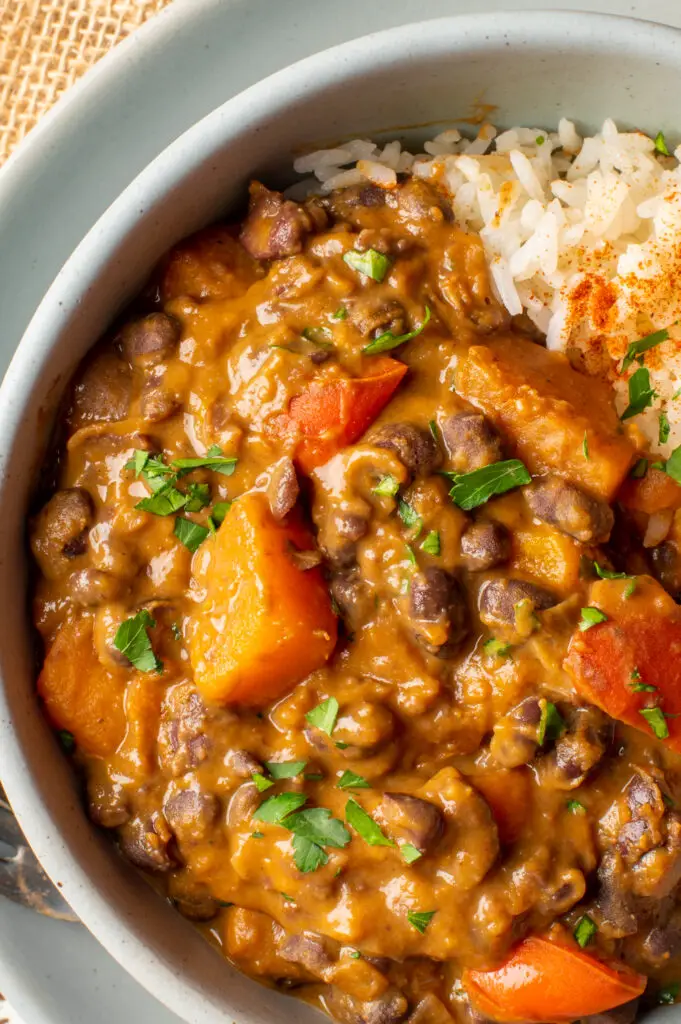 black bean and sweet potato stew with rice in pottery bowl