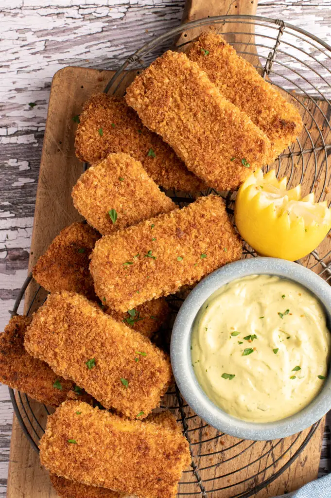 crispy tofu strips on cooling racks next to bowl of spicy cashew avocado mayo