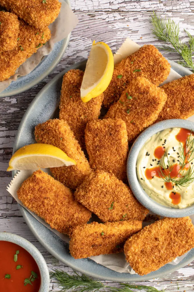 crispy tofu strips on plate next to bowl of spicy cashew avocado mayo