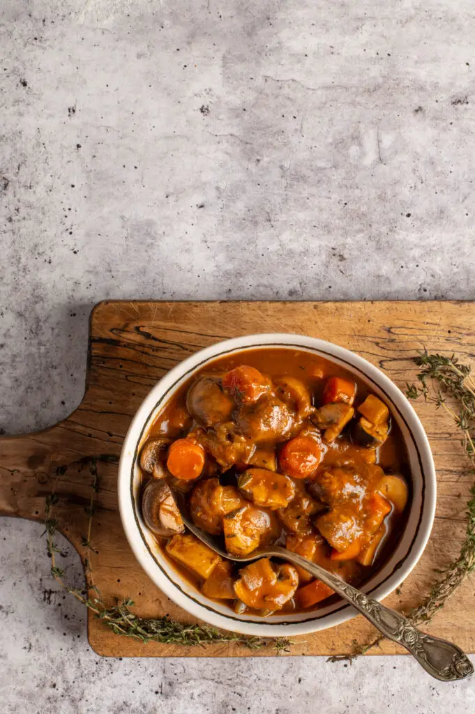 vegan irish guinness stew in bowl on cutting board