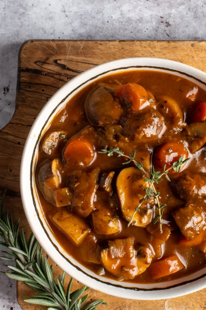 vegan irish guinness stew in bowl on cutting board