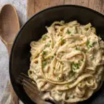 vegan pasta alfredo in black bowl on cutting board - food gawker image