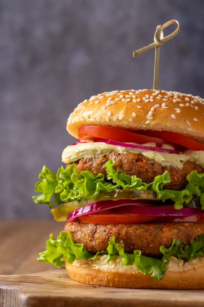 two chickpea veggie patties on bun with condiments