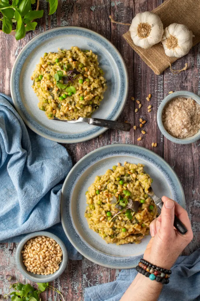 spring pesto risotto on two blue pottery plates