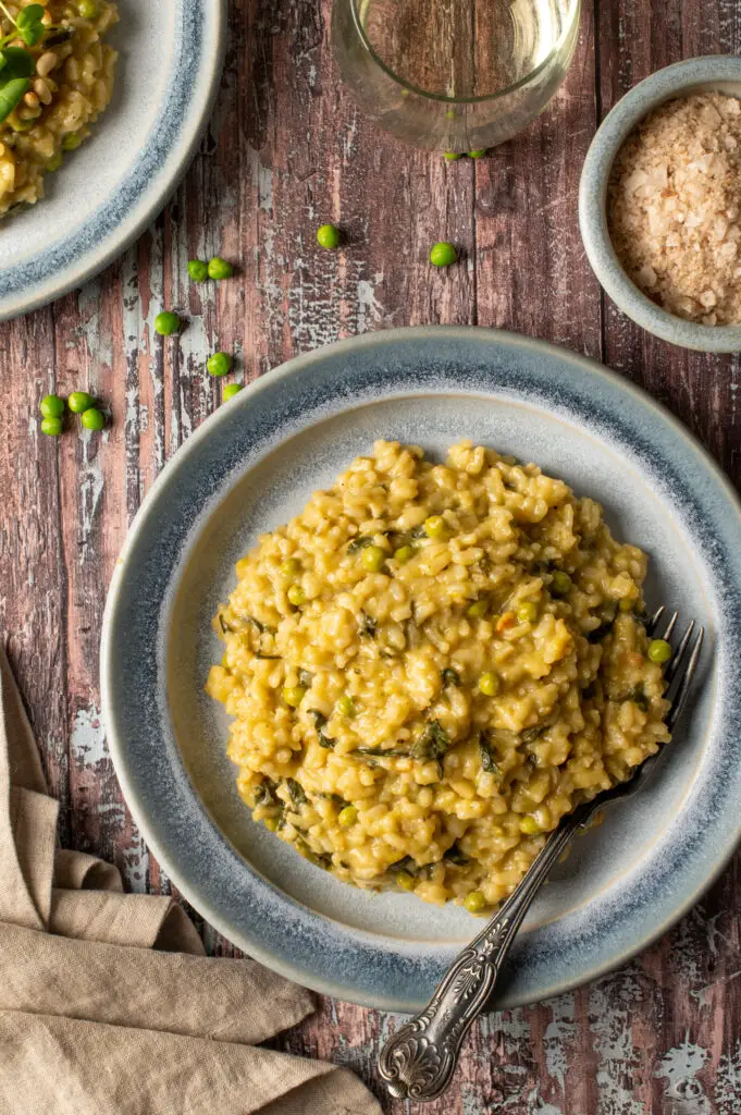 spring pesto risotto on blue pottery plate next to bowl of sea salt