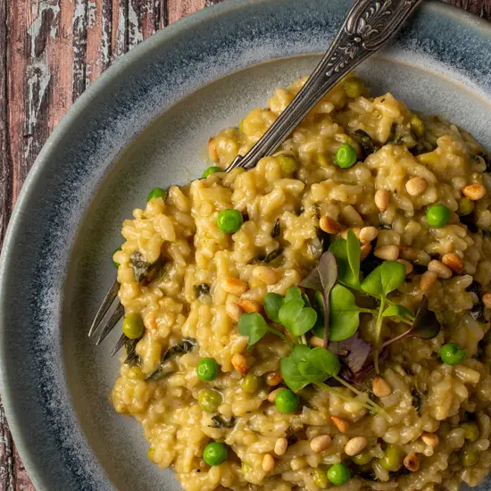 spring pesto risotto on blue pottery plate - recipe image