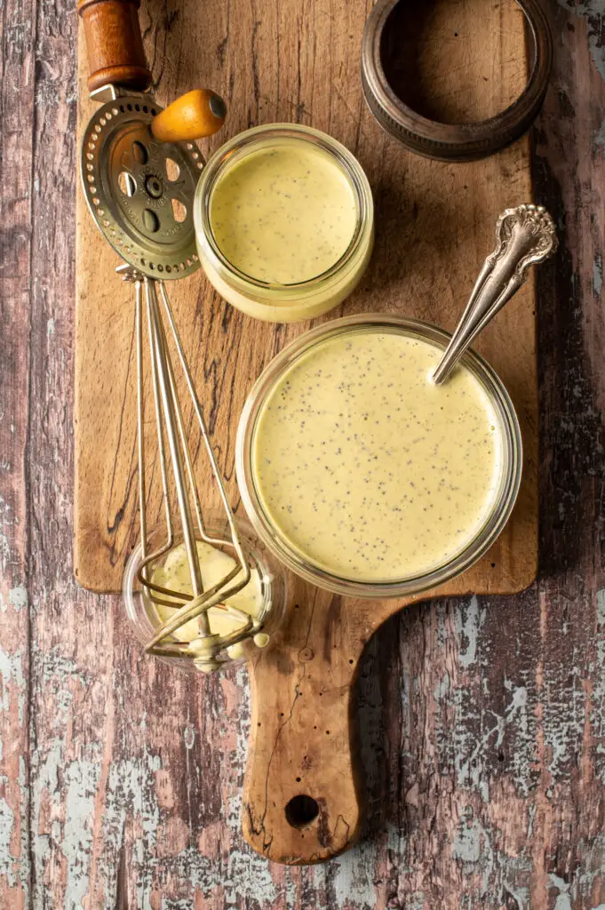 vegan lemon poppyseed dressing in glass jars on cutting board