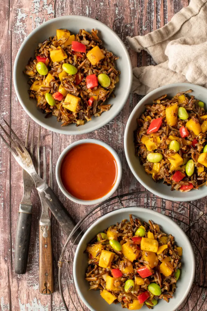 wild rice and mango salad in three small bowls