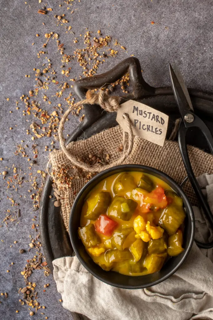 mustard pickles in black bowl sitting on cast iron griddle