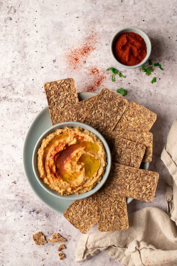 baba ganoush in bowl on plate with crackers