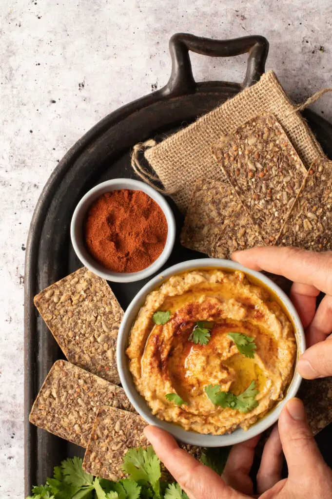 baba ganoush in bowl on iron serving plate with crackers