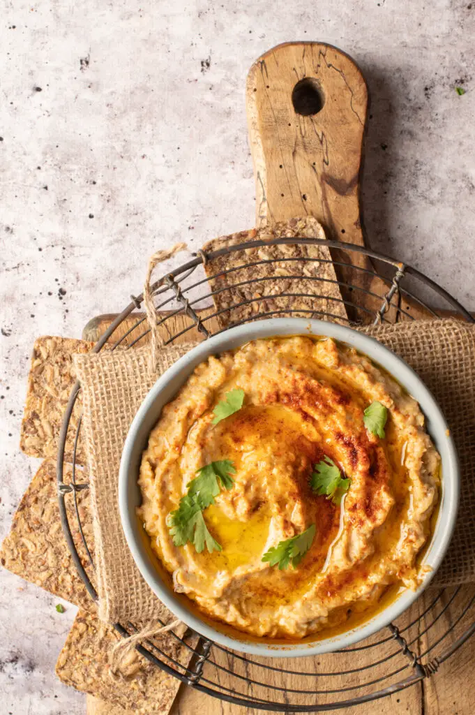 baba ganoush in bowl on cutting board with crackers