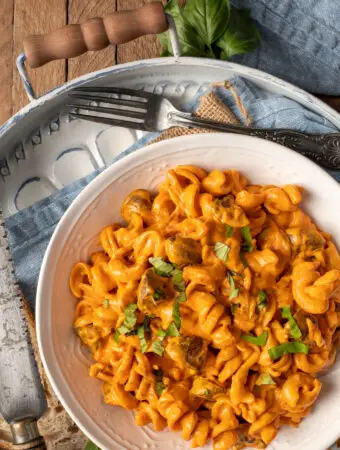 creamy roasted red pepper pasta in white bowl on tray