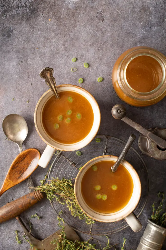 prepared vegetable broth in two soup mugs