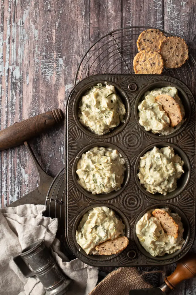 cashew spinach and artichoke dip in muffin tin