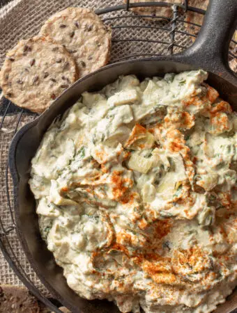 cashew spinach and artichoke dip in iron skillet