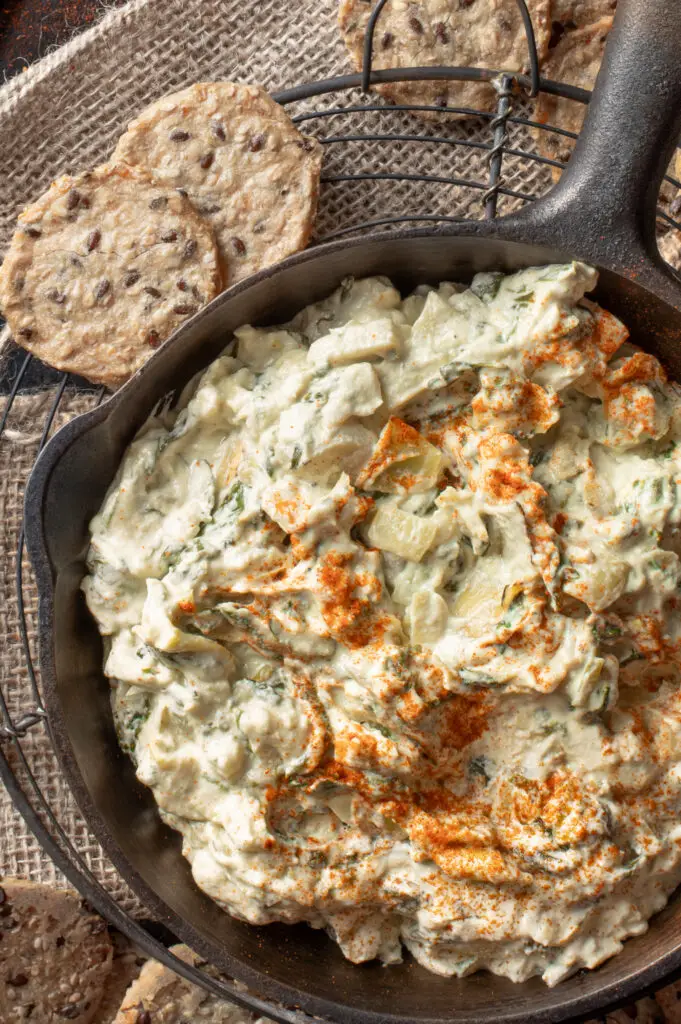 cashew spinach and artichoke dip in iron skillet