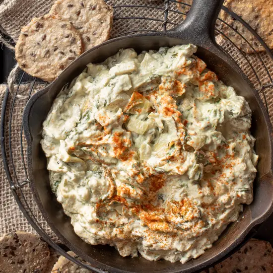 cashew spinach and artichoke dip in iron skillet - recipe image