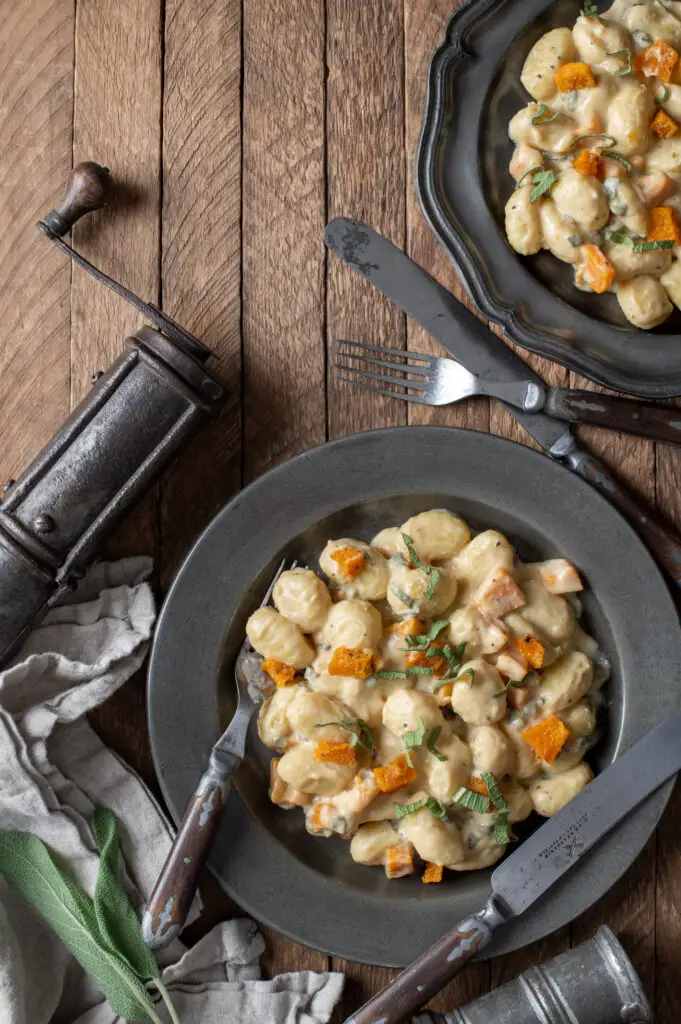 creamy butternut squash gnocchi on two pewter plates