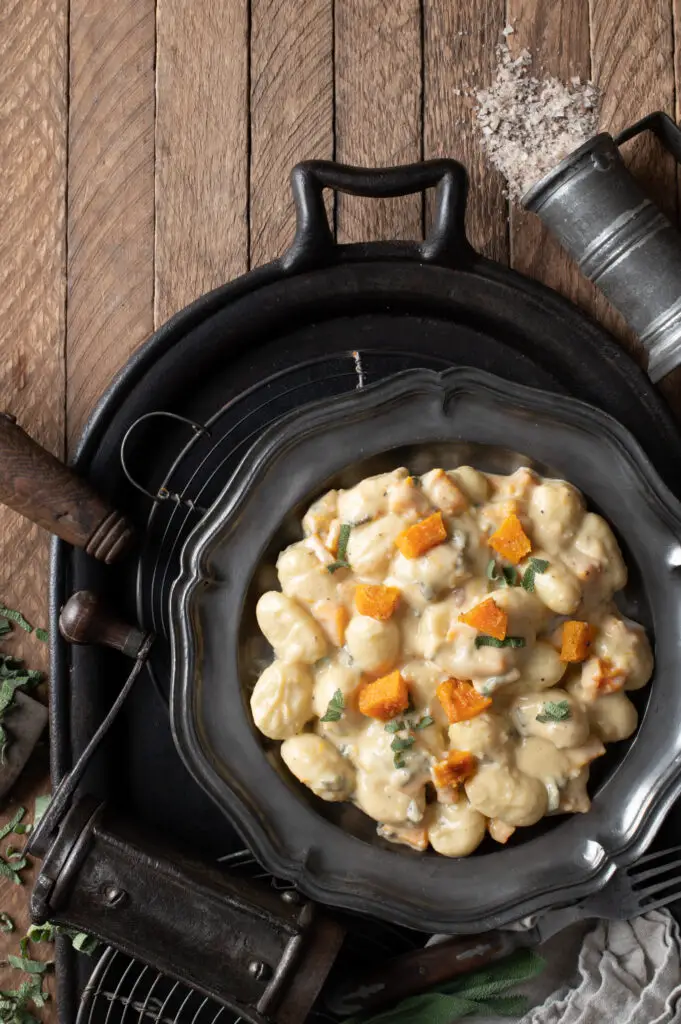 creamy butternut squash gnocchi on pewter plate