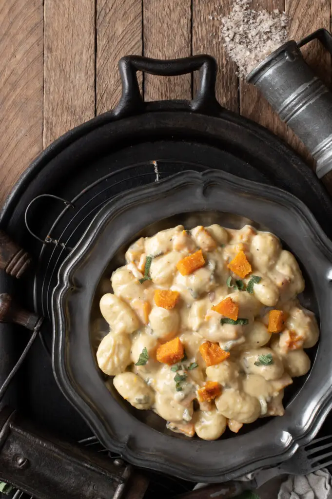 creamy butternut squash gnocchi on pewter plate